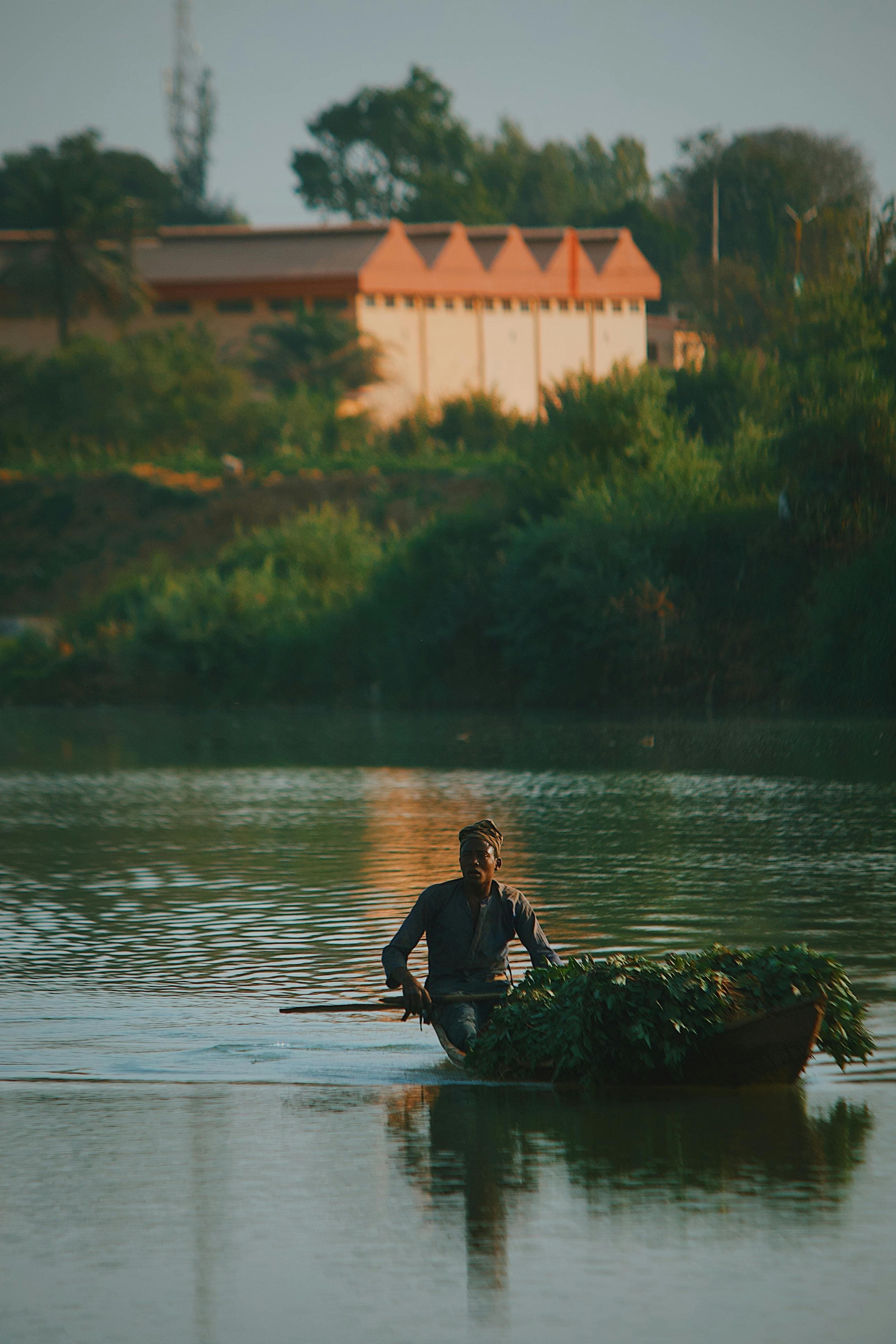 Hombre en piragua sobre el río Gambia al atardecer